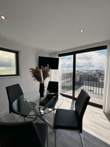 a dining room with a glass table and chairs at The Atlantis - Tower Apartments in Great Yarmouth