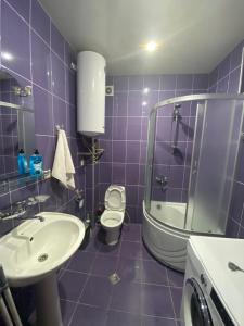 a purple bathroom with a toilet and a sink at Apartment in Poti in Poti