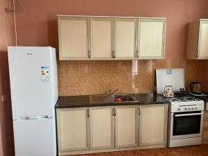 a kitchen with a white refrigerator and a sink at Apartment in Poti in Poti