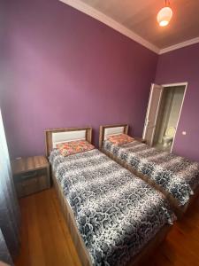 two beds in a room with purple walls at Apartment in Poti in Poti