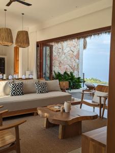 Umarato Villa Sumba في Rua: غرفة معيشة مع أريكة وطاولة