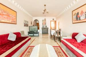 Sala de estar con 2 sofás rojos y TV en Appartement spacieux Centre Marrakech, en Marrakech