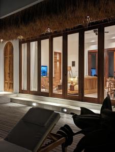 a room with a large group of windows and yoga mats at Umarato Villa Sumba in Rua