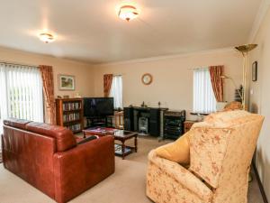 a living room with a couch and a chair at Bide-a-While in Marnoch