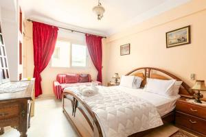 1 dormitorio con 1 cama, vestidor y cortinas rojas en Appartement spacieux Centre Marrakech, en Marrakech