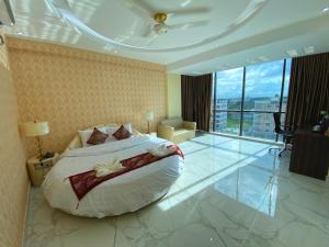 a hotel room with a bed and a large window at Hotel Valentino in Noākhāli +51 photos