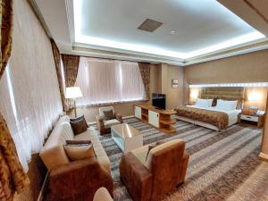 pokój hotelowy z łóżkiem, kanapą i krzesłami w obiekcie Graaf Hotel w mieście Baku