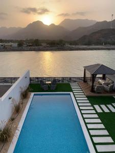Great Escape for family and friends 4BR Villa with Private Pool and Sea View في الفجيرة: مسبح امام جسم ماء