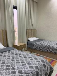 a hotel room with two beds and a window at Great Escape for family and friends 4BR Villa with Private Pool and Sea View in Fujairah