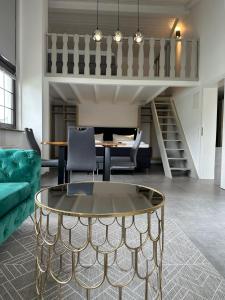 ein Wohnzimmer mit einem Glastisch und einer Treppe in der Unterkunft Hotel B4 in Limburg an der Lahn
