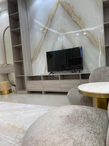 uma sala de estar com uma televisão de ecrã plano na parede em Great Escape for family and friends 4BR Villa with Private Pool and Sea View em Fujairah