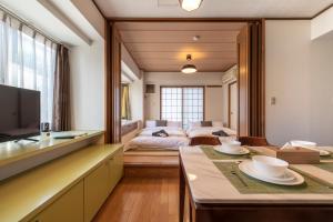 a living room with a bed and a table in a room at REJ Reflet Ebisu in Tokyo