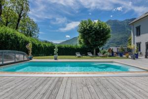 uma piscina num quintal com um deque de madeira em le clos grillet em La Chambre