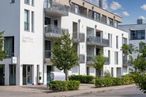 ein Mehrfamilienhaus mit Balkonen an einer Straße in der Unterkunft DünenResort Binz DünenResort Binz 125 in Binz