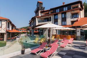 a group of chairs and umbrellas in front of a building at Ruskovets Thermal SPA & Ski Resort in Bansko