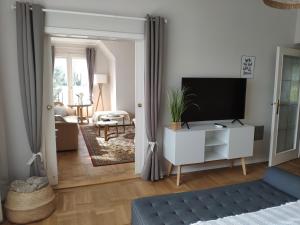 a living room with a tv and a white cabinet at HAuszeit - Zeit für dich - Zeit am See in Neufeld an der Leitha