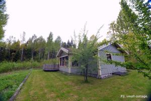 a small house in the middle of a yard at Nommen Fishing Cottages in Vetlanda