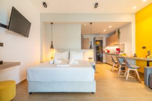 Luxury SeaSide Suites في خيرسونيسوس: غرفة نوم بسرير ابيض ومطبخ