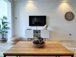a living room with a table and a tv at Casa Elsa with Free Parking in Los Abrigos