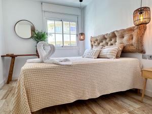 a bedroom with a bed with two swans on it at Casa Elsa with Free Parking in Los Abrigos