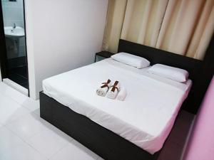 een slaapkamer met een bed met twee handdoeken erop bij Hotel Checkedinn in Ipoh