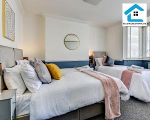 two beds in a room with white walls at Great Location, Ideal Place for your December Stay, Close to the beach, station and restuarants, Cosy House l by Bluehouse Short Lets Brighton in Brighton & Hove