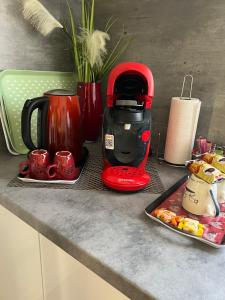 een rood koffiezetapparaat op een aanrecht met een bord eten bij Petit nid Catalan , 10 minutes des plages in Perpignan