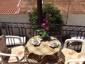 a table with a vase of flowers on a balcony at Sunshine Pension in Pythagoreio