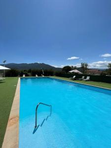 a large blue swimming pool with a metal rail at HOTEL LA GARENNE in Tresserre