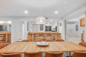 a dining room with a wooden table and chairs at Grand Slam Getaway with Tennis Court and Heated Pool in Kewarra Beach