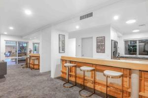 a restaurant with a bar with stools at Grand Slam Getaway with Tennis Court and Heated Pool in Kewarra Beach