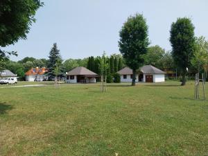 un gran campo de césped con casas y árboles en Polzer CAMPING BÜKFÜRDŐ en Bük