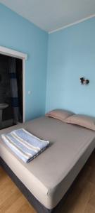 Cama en habitación con pared azul en Hôtel de France, en Limoges