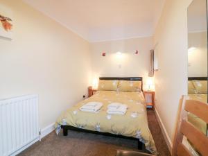 a bedroom with a bed with two towels on it at Katmoget Cottage in Cupar