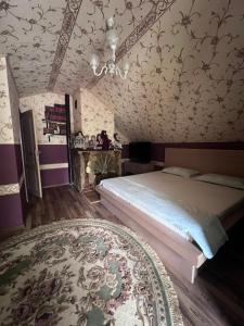 een slaapkamer met een bed, een tapijt en een kroonluchter bij Casa Izac in Botoşani