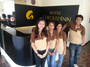 a group of people standing in front of a hotel checkedin sign at Hotel Checkedinn in Ipoh