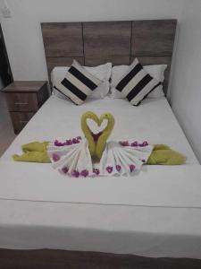 a white bed with a heart decoration on it at Blue bay in Blue Bay