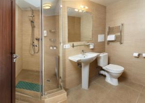 a bathroom with a toilet and a sink and a shower at Port Vesiegonsk Hotel in Ves'yegonsk