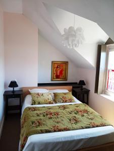 a bedroom with a bed with a green comforter at A Vol D'Oiseau in Honfleur