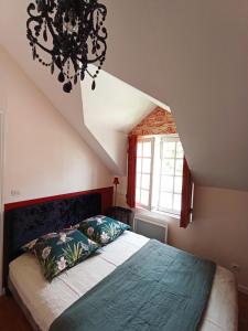 a bedroom with a bed and a chandelier at A Vol D'Oiseau in Honfleur