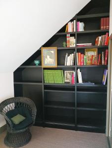 a black book shelf with a laptop on it at A Vol D'Oiseau in Honfleur