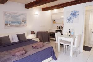 a bedroom with a bed and a table and a kitchen at SPQR Studios Valletta in Valletta