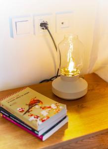 una lampada seduta sopra un tavolo con due libri di Oikia Preveza seaview a Preveza