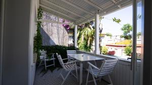 eine Veranda mit einem Tisch und Stühlen auf dem Balkon in der Unterkunft Büyükada Ece Suit in Adalar