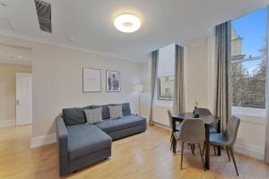 a living room with a couch and a table at Cleveland Residences Kensington in London