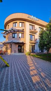 a building with a cobblestone street in front of it at Vila La Mer in Eforie Nord