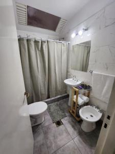 a bathroom with two sinks and a toilet and a mirror at Casa Amplia en Pleno Centro Histórico in Salta