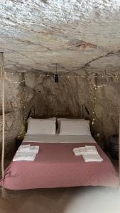 a bedroom with a bed in a cave with lights at Grotta Carlotta in Ostuni