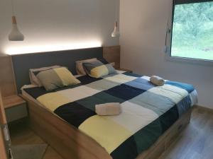 uma cama grande num quarto com duas almofadas em Apartma Bella Nadiža em Kobarid