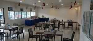 restauracja ze stołami i krzesłami w pokoju w obiekcie Winterfeel Resort w mieście Alappuzha